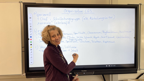 Auf diesem Bild sieht man eine Lehrerin an einem Panel.