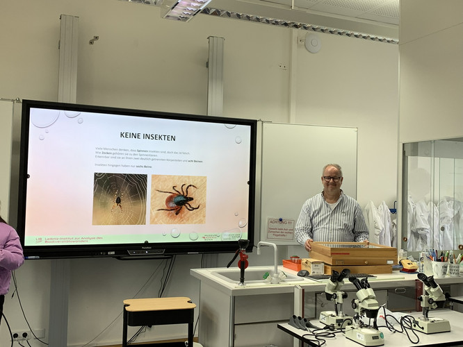 Auf diesem Bild sieht man eine Lehrkraft vor einem Panel.