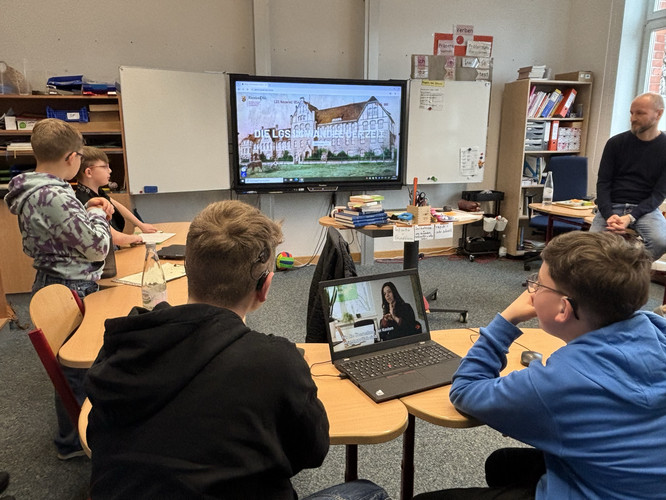 Auf diesem Bild sieht man eine Schülergruppe vor einem Panel.