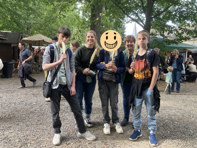 Auf diesem Bild sieht man Schüler und Erzieherinnen mit Stockbroten.