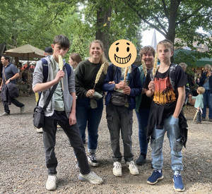 Auf diesem Bild sieht man Schüler und Erzieherinnen mit Stockbroten.