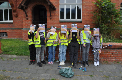 Auf diesem Bild sieht man eine Schülergruppe mit Urkunden vor dem Hauptgebäude.